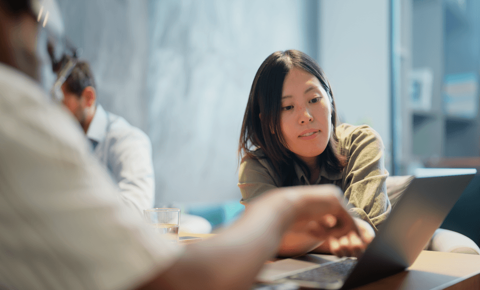 woman and man collaborating over an open laptop
